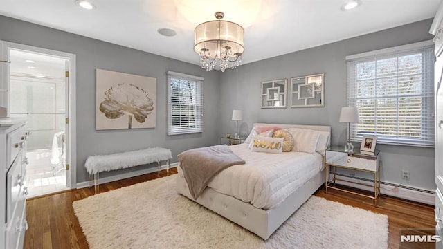 bedroom featuring ensuite bathroom, dark wood-type flooring, a baseboard radiator, and a chandelier