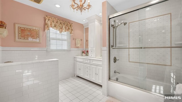 bathroom featuring tile walls, vanity, tile patterned floors, and combined bath / shower with glass door