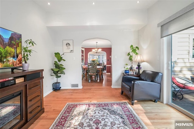 living room featuring a notable chandelier and light wood-type flooring