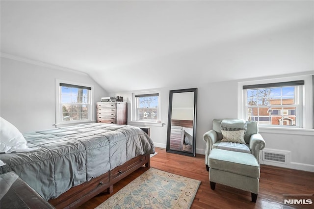 bedroom with lofted ceiling, dark hardwood / wood-style floors, and multiple windows