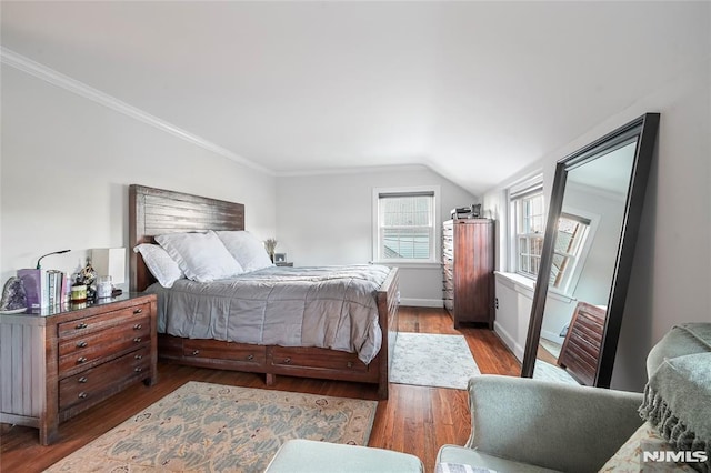 bedroom featuring dark wood-type flooring, vaulted ceiling, and crown molding