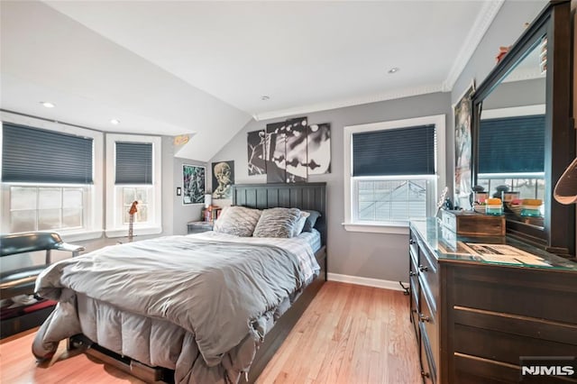 bedroom with lofted ceiling, ornamental molding, and light hardwood / wood-style floors