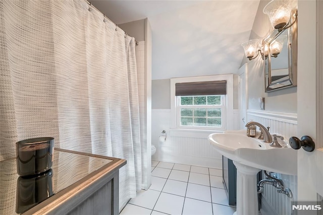 bathroom with toilet, tile patterned floors, and vaulted ceiling