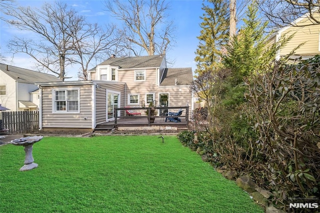 rear view of property with a yard and a wooden deck