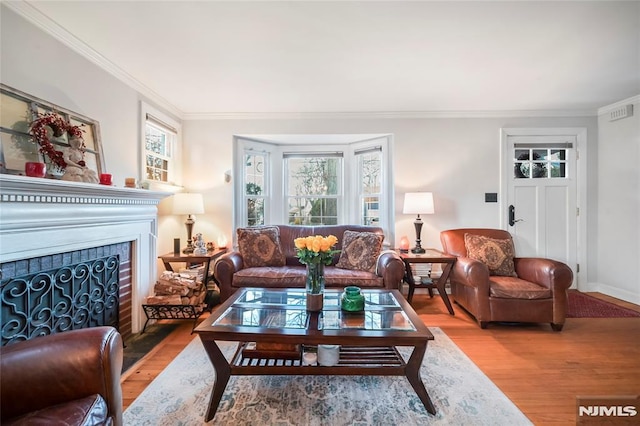 living room featuring a fireplace, hardwood / wood-style flooring, and crown molding