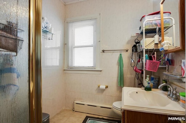 bathroom with a shower with door, vanity, a baseboard heating unit, and plenty of natural light