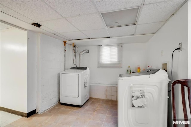 laundry area featuring washing machine and clothes dryer and light tile patterned floors