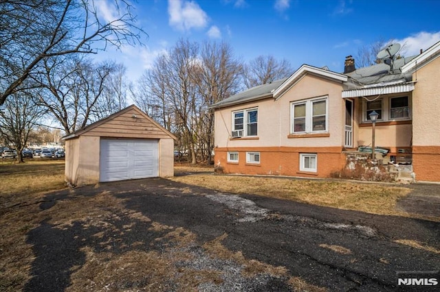 view of property exterior with a garage and an outbuilding