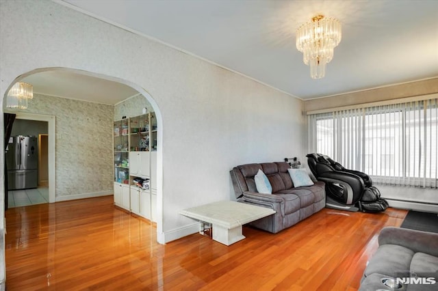 living room with a baseboard heating unit, a notable chandelier, and hardwood / wood-style floors