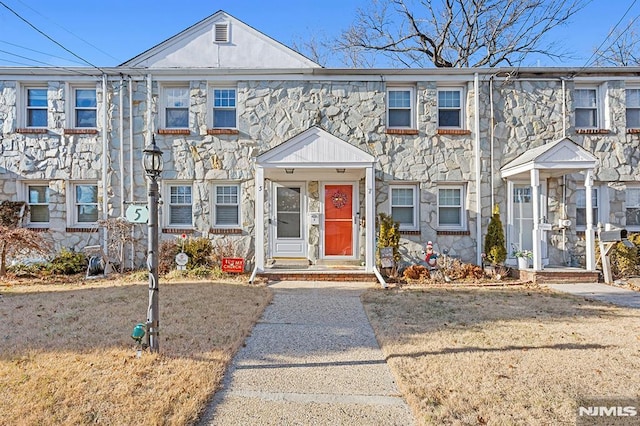 townhome / multi-family property featuring a front yard