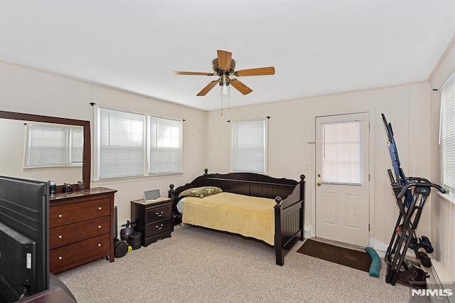 bedroom with multiple windows, ceiling fan, and light colored carpet