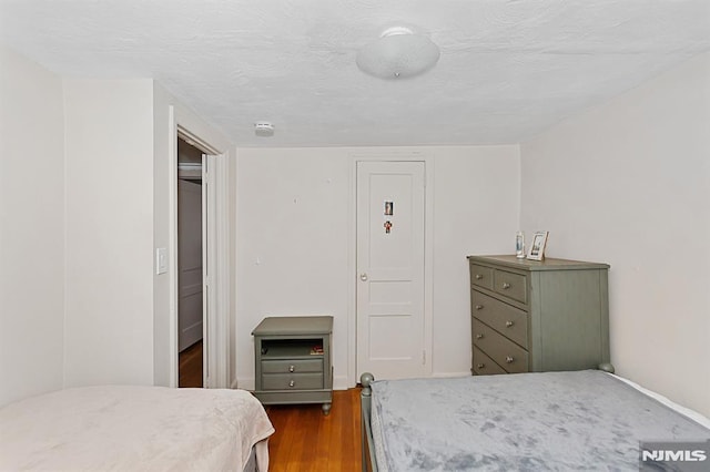 bedroom with dark wood-type flooring