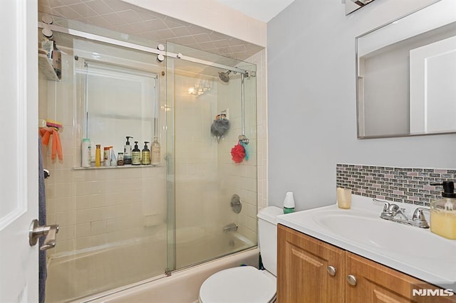 full bathroom with toilet, bath / shower combo with glass door, tasteful backsplash, and vanity