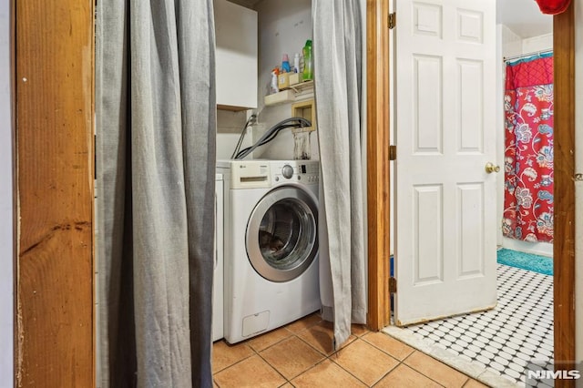 laundry room with washer / dryer and light tile patterned floors