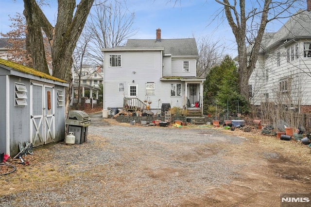 back of property featuring an outbuilding