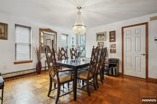 dining space with a baseboard radiator, parquet flooring, and a chandelier