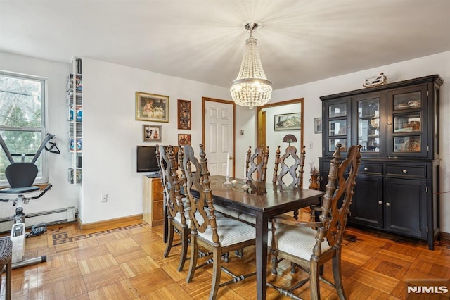 dining area featuring a notable chandelier and light parquet floors