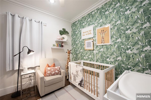 bedroom featuring light tile patterned floors, a nursery area, and ornamental molding