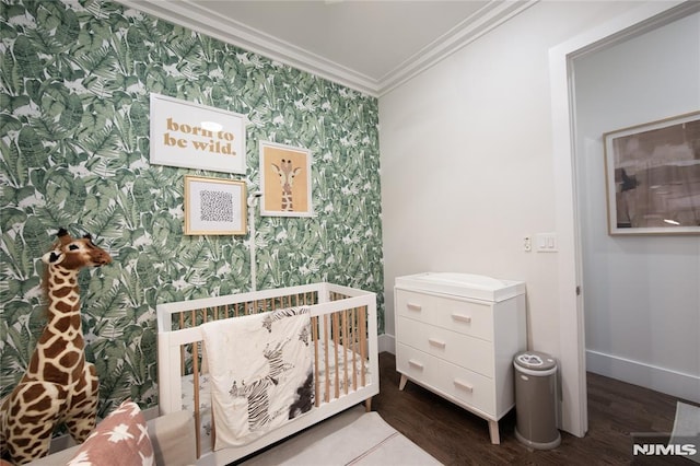 bedroom with crown molding, dark wood-type flooring, and a crib