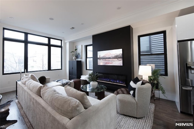 living room with hardwood / wood-style floors, crown molding, and a fireplace