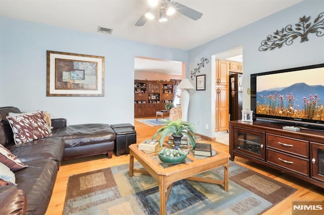 living room featuring light hardwood / wood-style floors and ceiling fan