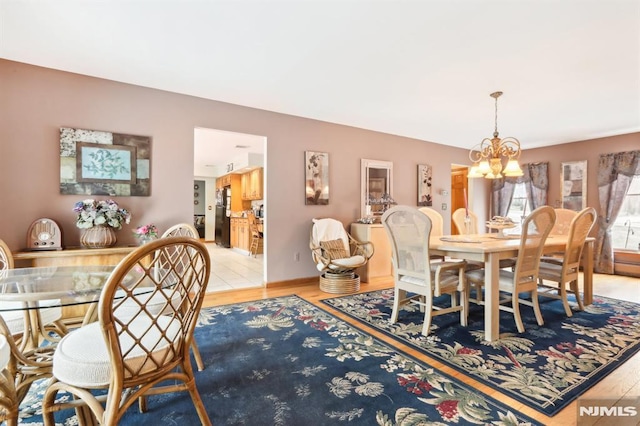 dining area featuring an inviting chandelier and light hardwood / wood-style floors