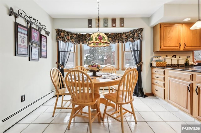 tiled dining room featuring a baseboard heating unit