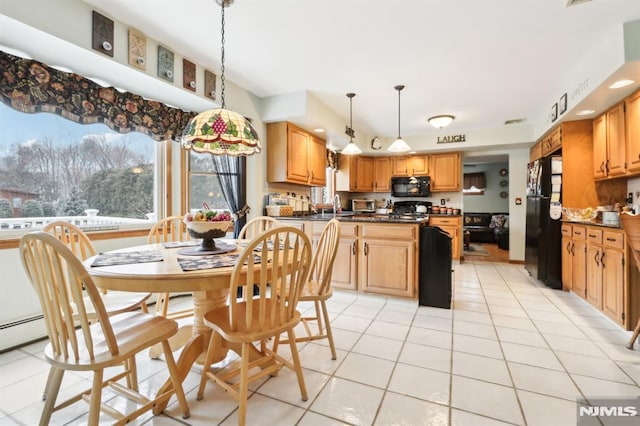 kitchen with black appliances, hanging light fixtures, and light tile patterned flooring