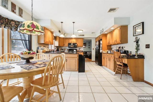 kitchen featuring black appliances, pendant lighting, kitchen peninsula, and light tile patterned floors