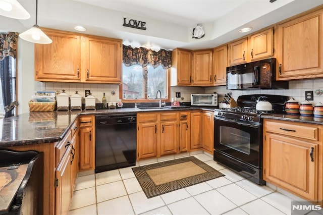 kitchen with hanging light fixtures, light tile patterned floors, black appliances, decorative backsplash, and sink