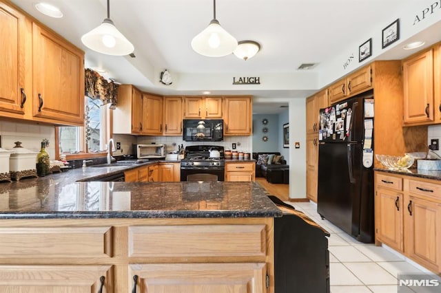 kitchen featuring backsplash, decorative light fixtures, black appliances, and kitchen peninsula