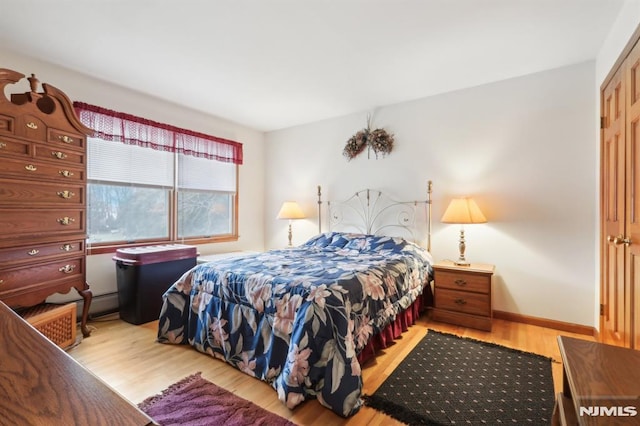 bedroom with light hardwood / wood-style floors and a closet