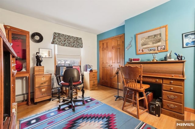 office space featuring a baseboard radiator and light hardwood / wood-style flooring