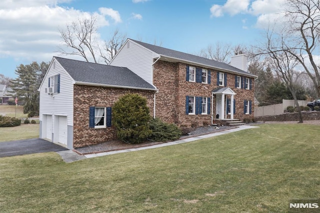 colonial house featuring a front yard and a garage