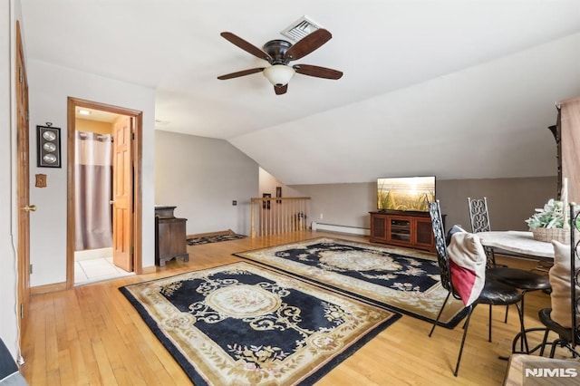 additional living space featuring hardwood / wood-style floors, a baseboard heating unit, ceiling fan, and vaulted ceiling