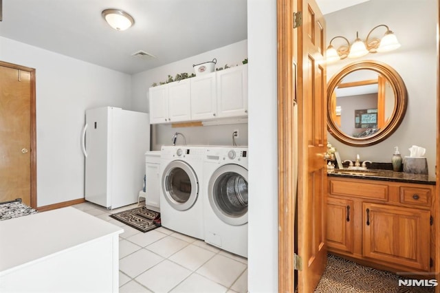 laundry area featuring washer and dryer, cabinets, light tile patterned flooring, and sink