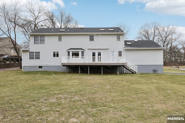 rear view of property with a lawn and a wooden deck