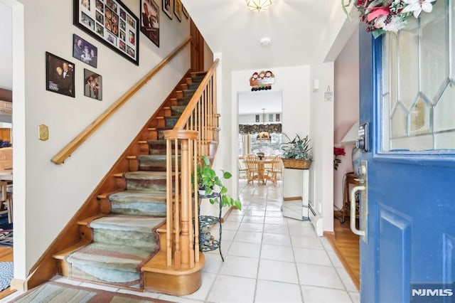 foyer entrance featuring light tile patterned flooring and a baseboard radiator