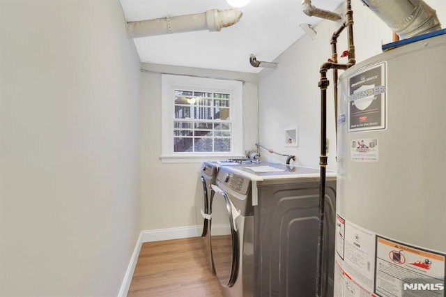 laundry area with water heater, light wood-type flooring, and separate washer and dryer