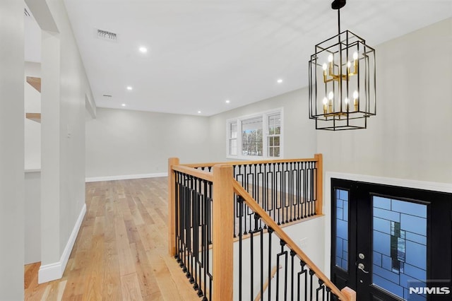 hall featuring a chandelier and light wood-type flooring