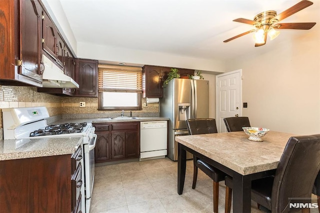 kitchen featuring sink, white appliances, ceiling fan, decorative backsplash, and dark brown cabinets