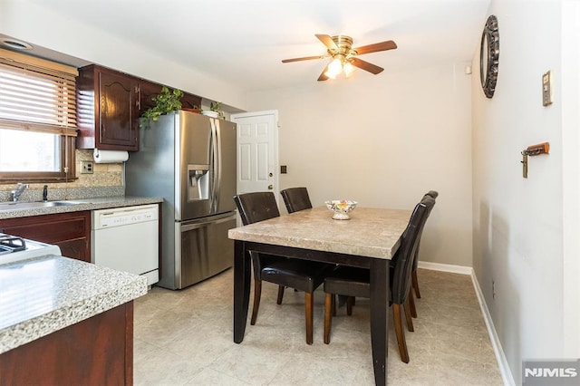 dining room featuring ceiling fan and sink