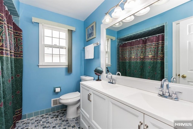 bathroom with a shower with shower curtain, vanity, and toilet