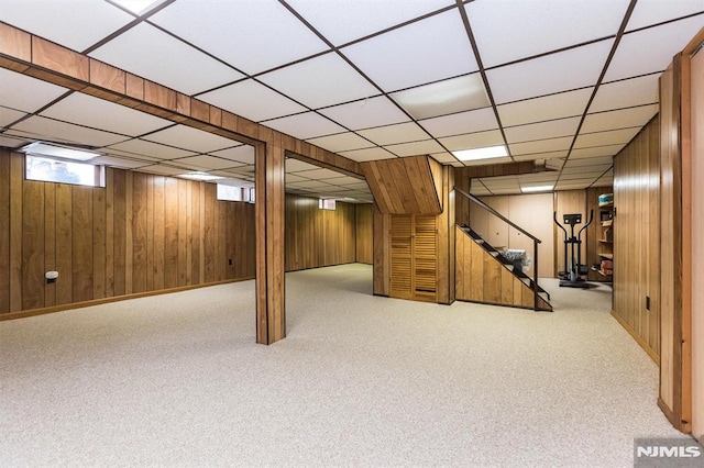 basement featuring wood walls and light carpet