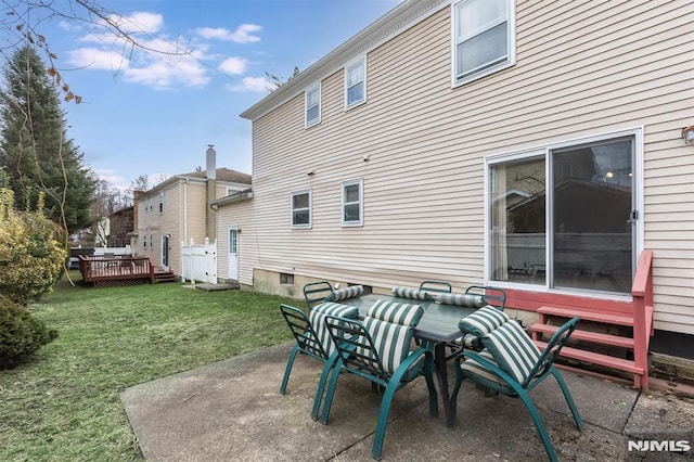 back of house with a deck, a patio area, and a yard