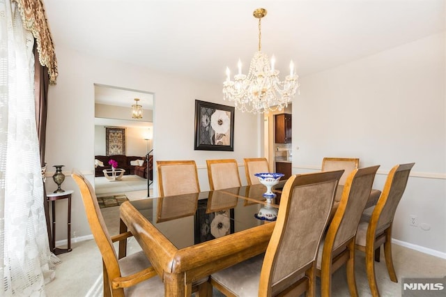 carpeted dining area featuring a notable chandelier