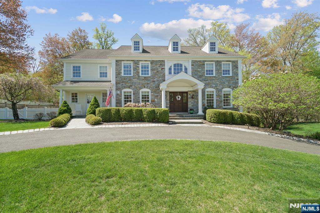 27 Howard St, Wyckoff, NJ 07481 - colonial inspired home featuring fence, a front lawn, and stone siding