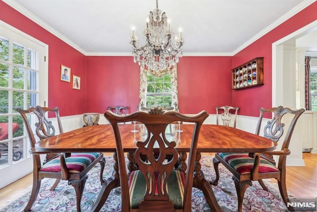 dining area featuring a notable chandelier, light hardwood / wood-style flooring, and crown molding