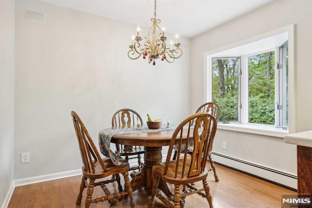 dining room featuring a baseboard heating unit, an inviting chandelier, and hardwood / wood-style flooring