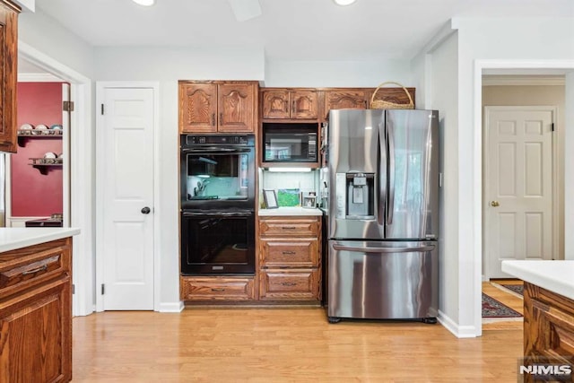 kitchen featuring light wood-type flooring and black appliances